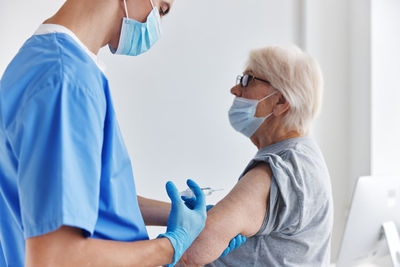 Side view of doctor examining patient at clinic