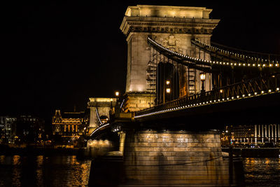 Low angle view of szechenyi chain bridge over river against sky at night