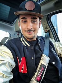 Portrait of young man sitting in car