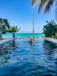 View of woman swimming in pool against sky