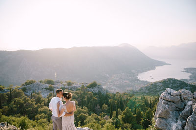 Rear view of woman looking at mountains against sky