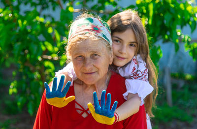 Portrait of young woman standing against plants