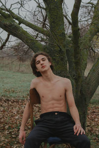 Portrait of young man sitting in forest