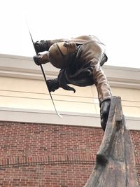 Low angle view of statue against wall