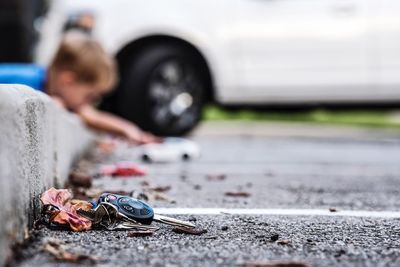 High angle view of car key on street by dry leaf