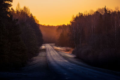 A beautiful landscape with a country road in misty morning during the sunrise. 