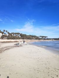 Scenic view of beach against blue sky