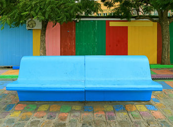 Empty chairs and tables in swimming pool against building