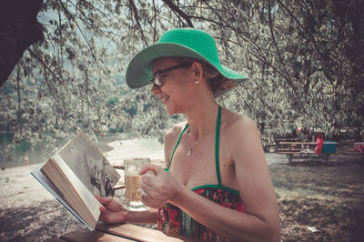 Side view of woman holding hat