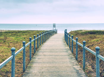 View of wooden pier on sea against sky