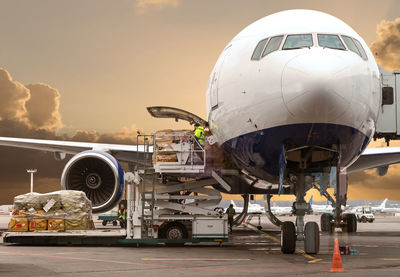 Airplane on airport runway against sky