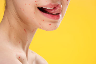 Close-up of woman face against yellow background