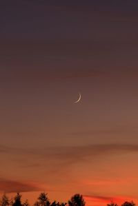 Low angle view of silhouette moon against sky at sunset