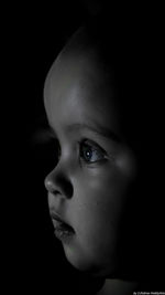 Close-up of baby girl over black background