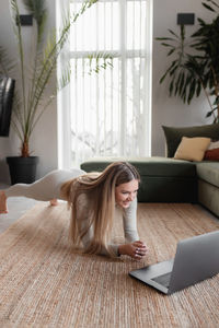 Healthy sport lifestyle concept, happy smiling blogger girl doing yoga exercises at home