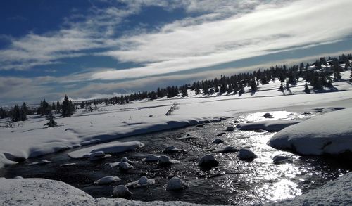 Scenic view of frozen landscape against sky