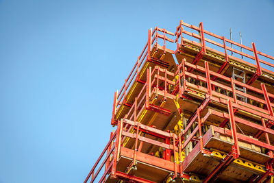 Low angle view of crane against clear blue sky