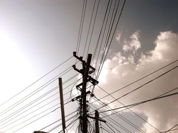 Low angle view of silhouette electricity pylon against sky