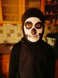 Portrait of boy with spooky face paint at home during halloween