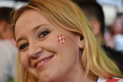 Close-up portrait of smiling woman with blond hair