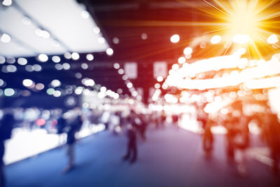 Defocused image of crowd in illuminated city at night