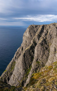 Rock formations by sea against sky