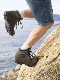 Low section of man climbing on rock