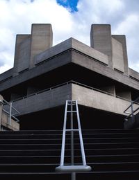 Low angle view of modern building against cloudy sky