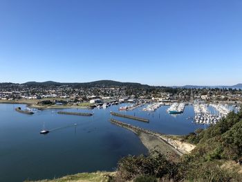 High angle view of city by sea against clear sky