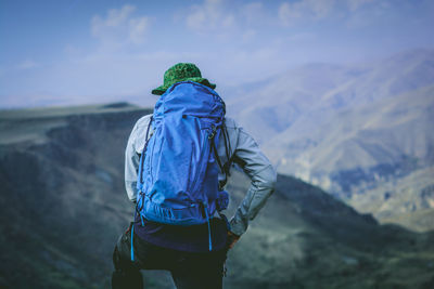 Rear view of man looking at mountain range