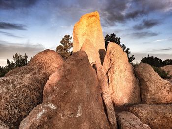 Low angle view of rock formation against cloudy sky