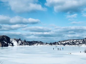 People on snowcapped mountain against sky