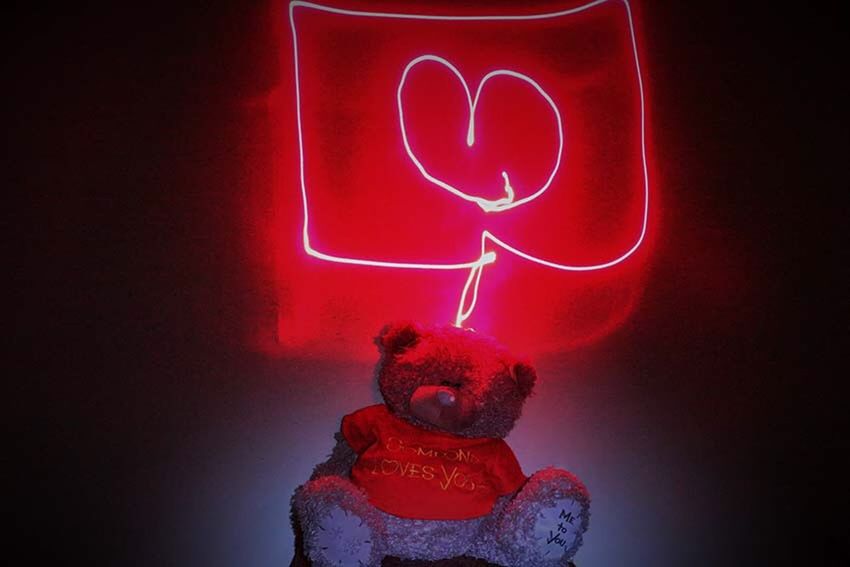 red, indoors, art and craft, creativity, art, close-up, human representation, illuminated, single object, lighting equipment, still life, decoration, studio shot, candle, heart shape, black background, hanging, no people, ideas