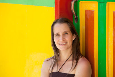 Young tourist woman next to one of the colorful doors of the guatape town in the region of antioquia