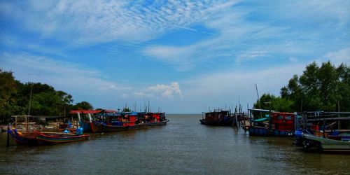 Boats moored in sea against sky