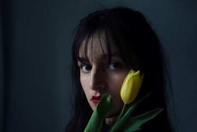 Close-up portrait of woman against black background