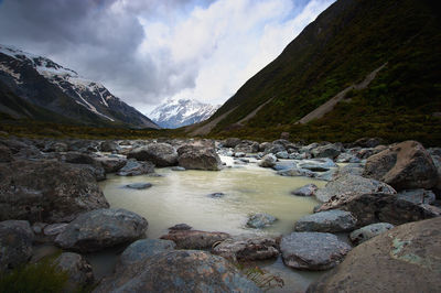 Scenic view of river and mountains against sky