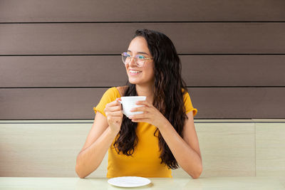 Cheerful woman drinking coffee in cafe