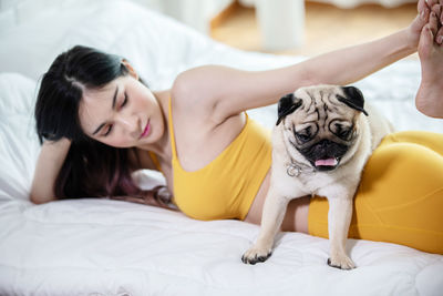 Young woman lying on bed with dog