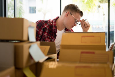 Man by cardboard boxes at office