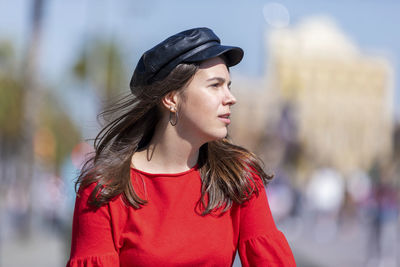 Teenage girl wearing red top in city during sunny day