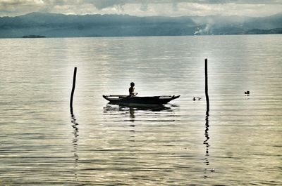 Man on lake against sky