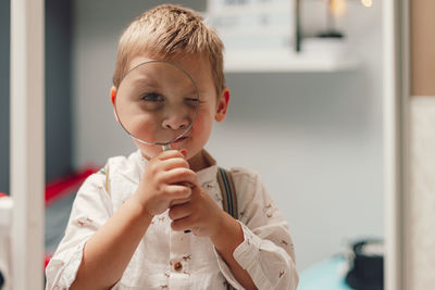 Cute little boy holding magnifaying glass