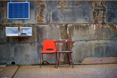 Empty chairs and tables against wall in old building