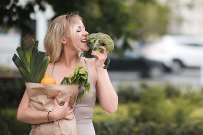 Young woman eating broccoli