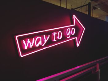 Low angle view of illuminated information sign at night