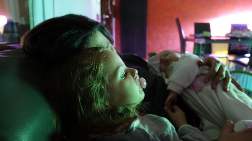 Close-up of baby girl sleeping on bed at home