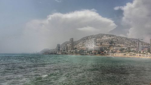 Scenic view of sea and buildings against sky