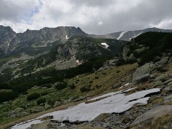 Scenic view of mountains against cloudy sky