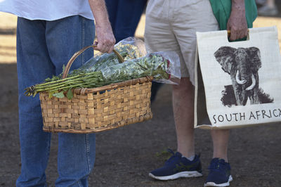 Low section of man standing by basket